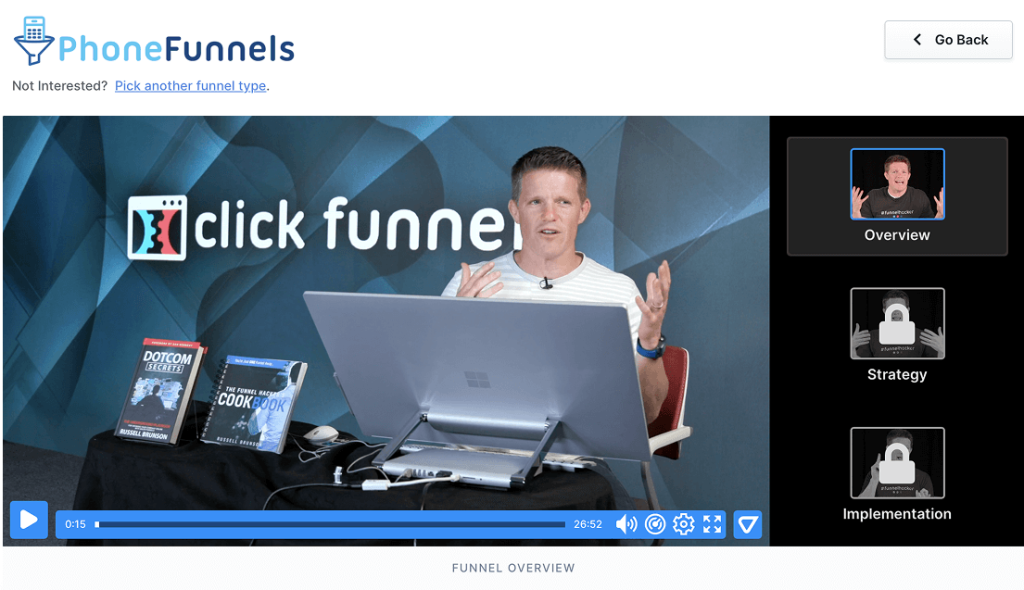 Russell Brunson sits at a desk with books and a laptop, giving a presentation about ClickFunnels application funnel overview. On the right, a menu shows Overview selected, with Strategy and Implementation locked.